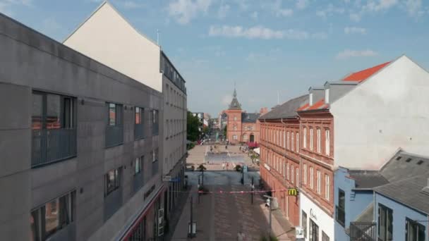 Adelante vuelo lento a través de la calle Torvegade en Esbjerg, Dinamarca. Dolly aérea sobre la famosa plaza Torvet con edificios de ladrillo y la estatua de Christian IX — Vídeo de stock