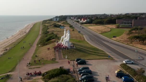 Αεροφωτογραφία της παραλίας του Esbjerg, με αργή περιστροφή της κάμερας γύρω από το άγαλμα του Man Meets the Sea. Υψηλή γωνιακή άποψη του διάσημου γλυπτού od με πολλούς τουρίστες που επισκέπτονται. Esbjerg, Δανία — Αρχείο Βίντεο