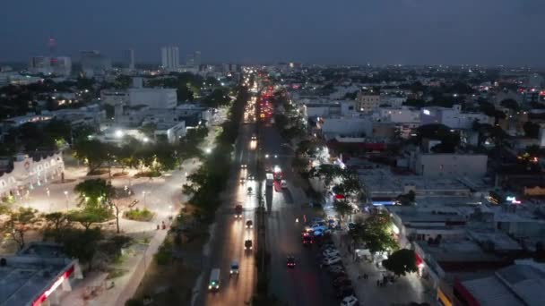 Adelante vuelan sobre la concurrida calle por la noche. Coches conduciendo por carretera de varios carriles. Vida nocturna en el barrio. Cancún, México — Vídeo de stock