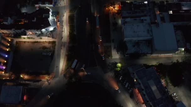 Vista de ángulo alto de la intersección de carreteras. Inclinado hacia arriba revelan larga calle recta concurrida y vista panorámica de la ciudad por la noche. Cancún, México — Vídeo de stock