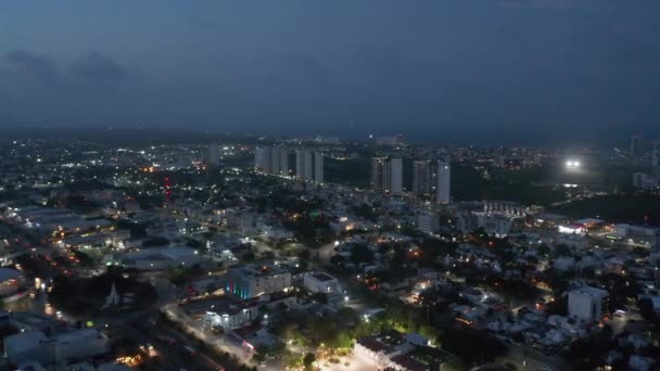 Aerial panoramic footage of urban neighbourhood at night. Tall modern buildings in apartment complex in background. Cancun, Mexico — Stock Video