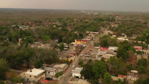 Vue aérienne de voitures conduisant dans la rue dans une banlieue pauvre. Bâtiments bas d'un étage en ville. Valladolid, Mexique — Video