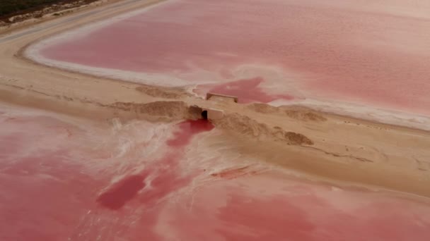 Vista aérea de alcantarilla entre dos lagos rosados. Extraño color de agua coloreado por microorganismos específicos. Las Coloradas, Yucatán, México — Vídeo de stock