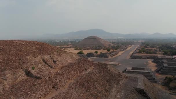 Vlieg rond de top van de piramide van de maan, onthullen lange historische straat met archeologische bezienswaardigheden. Oude site met architectonisch significante Meso-Amerikaanse piramides, Teotihuacan, Mexico — Stockvideo