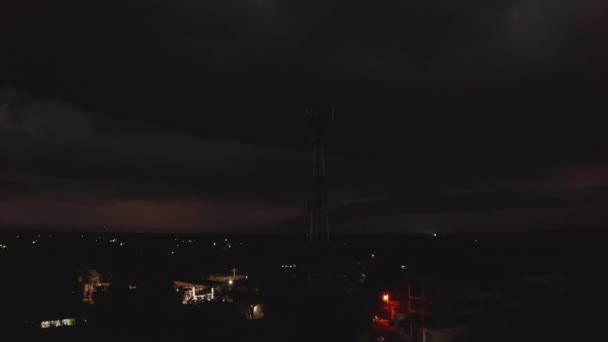 Filmato panoramico ascendente di suburbano, operatore mobile antenna albero e distributore di benzina illuminato. Tempesta in lontananza. Valladolid, Messico — Video Stock