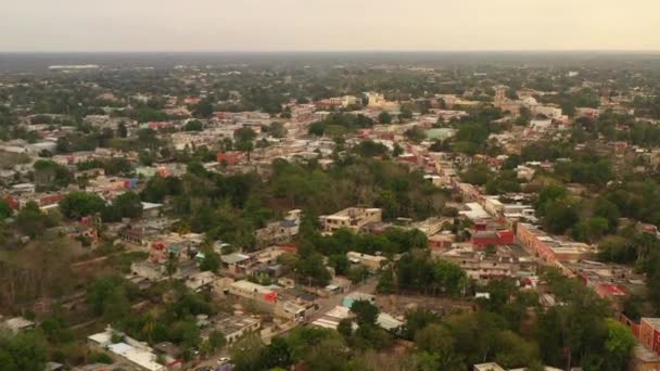 Aerial ascending footage of building in town. Streets lined with low houses. Living in poor conditions. Valladolid, Mexico — Stock Video