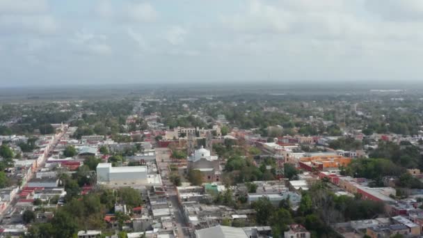 Voorwaarts vliegen boven de stad. Luchtfoto van Iglesia de San Servacio, christelijke kerk en openbaar park voor de deur. Valladolid, Mexico — Stockvideo