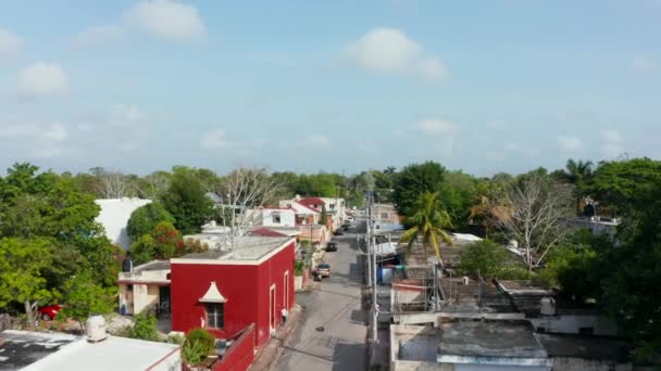 열 대 지방의 교외 지역에서는 길 위로 날아 다닙니다. 길가에 차들 이 주차 되어 있는 여러 채 의집들. 멕시코, 발라 돌 리드 — 비디오