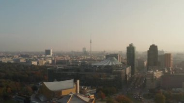 Forvetler, Potsdamer Platz çevresindeki modern kentsel bölgenin üzerinde uçuyor. Fernsehturm TV kulesi uzakta. Berlin, Almanya