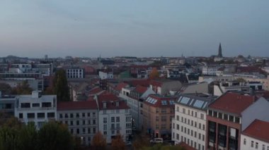 Akşamlar şehir merkezinin üzerinde geçiyor. Sokaklar boyunca çok katlı apartmanlar. Berlin, Almanya
