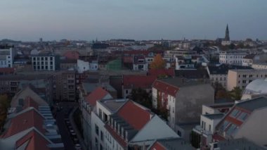 Daha geniş şehir merkezindeki konut binalarının üzerinde uçmak, alacakaranlıkta apartman blokları. Berlin, Almanya