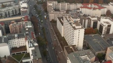 Geniş sokağın yüksek açılı manzarası şehir mahallesinden geçiyor. Kalabalık yol boyunca uzun binalar. Berlin, Almanya