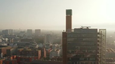 Yüksek modern binanın tepesindeki gözcü terasında duran adamın görüntülerini geri al. Sabah güneşine karşı hava manzarası. Berlin, Almanya