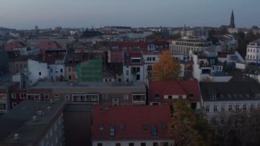 Kentsel çevredeki çeşitli binaların düşük ışık manzarası. Alacakaranlıkta büyük kasabanın üzerinden uç. Berlin, Almanya