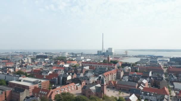 Framåt långsam flykt över staden Esbjerg med kyrkan Vår Frälsare. Fågelögon avslöjar hans hamn med skorstenen från kol- och oljedrivna kraftverket, Nordens högsta — Stockvideo