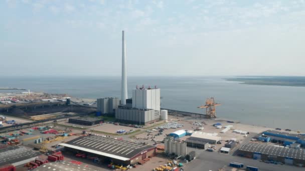 El ojo de las aves gira lentamente alrededor de la chimenea de la central eléctrica de Steelcon en Esbjerg, Dinamarca. Vista aérea del dron de la central eléctrica de carbón y petróleo con la chimenea más alta de Escandinavia — Vídeos de Stock