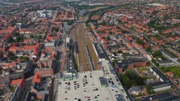 Προς τα πίσω πετούν πάνω από το σιδηροδρομικό σταθμό που βρίσκεται στο κέντρο της μικρής πόλης της Δανίας. Αεροφωτογραφία της μικρής δανέζικης πόλης. Esbjerg Banegard, Esbjerg, Δανία. — Αρχείο Βίντεο