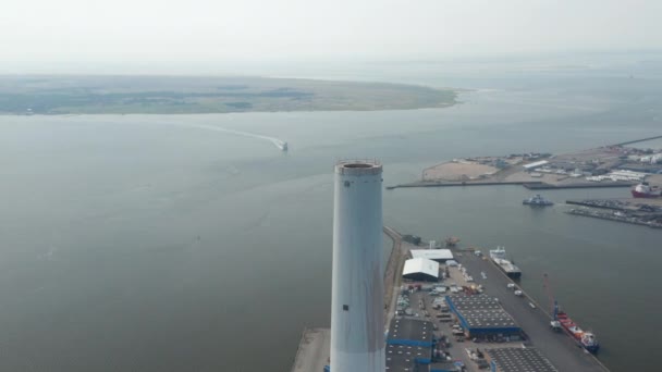 Αεροφωτογραφία που πετούν γύρω από την καμινάδα του σταθμού παραγωγής ηλεκτρικής ενέργειας Esbjerg στη Δανία. Κηφήνας άποψη τροχιά αποκαλύπτοντας το λιμάνι και την εκπληκτική ορίζοντα της πόλης — Αρχείο Βίντεο