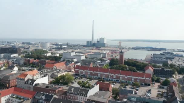 Αεροφωτογραφία πάνω από την πόλη του Esbjerg με το λιμάνι του και την καμινάδα του σταθμού παραγωγής ηλεκτρικής ενέργειας με καύση άνθρακα και πετρελαίου. Αυτή η καμινάδα είναι η ψηλότερη σε όλη τη Σκανδιναβία. — Αρχείο Βίντεο
