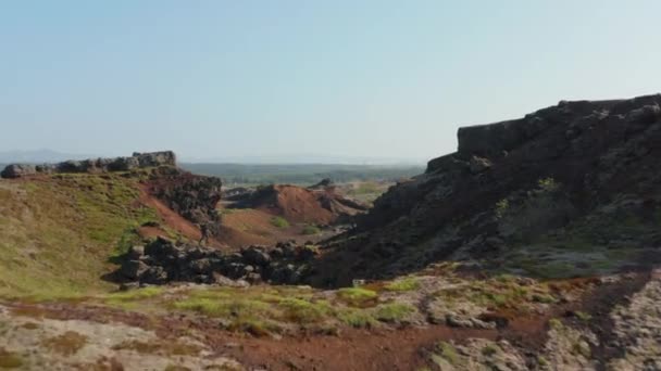 Vista aérea do homem explorador mochileiro correndo caminhadas uma formação de rocha na Islândia. Drone vista do jovem turista descobrindo incrível deserto de deserto panorama com penhasco de pedra — Vídeo de Stock