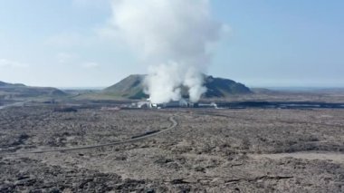 İzlanda 'daki bir jeotermal santralin üzerinde uçan hava manzarası. Drone Görünümü enerji santrali üzerinde alternatif yeşil enerji buharlı sıcak su üretiyor