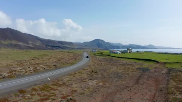 Вид на Кільцеву дорогу - шосе Ісландії, що проходить по всьому острову. Повітряний вид показує деякі фермерські будинки з сільськогосподарськими машинами. — стокове відео