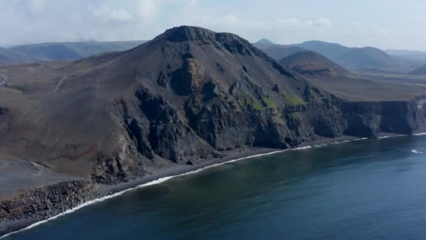 Vista drone de espetacular penhasco vulcânico negro na Islândia. Vista aérea costa de praia de areia preta com ondas oceânicas em queda — Vídeo de Stock