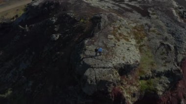 İnsansız hava aracı, İzlanda 'daki tepede manzaranın keyfini çıkaran iki yürüyüşçüyü görüyor. Kuş bakışı gezginler İHA 'yı kaydedip doğada güzelliğin tadını çıkarıyorlar.