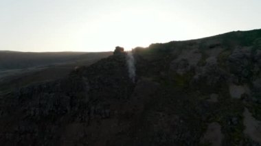 İzlanda 'nın arka planında kuş gözüne doğru uçuyor. Gün batımında tepedeki kayalık oluşumların yukarıdan görünüşü. İnsan yok. Hayret verici.
