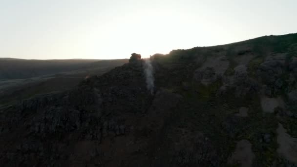 Flyger mot fåglar öga bakgrundsbelyst av Island höglandet. Flygfoto ovanifrån över steniga formationer kulle i bakgrundsljus vid solnedgången. Inga människor. Fantastiskt på jorden — Stockvideo
