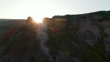 İzlanda 'nın dağlık kesimlerinde kükürt buharı tüten fümerollü kayalık oluşumların arka plan görüntüsü. Kayalık tepeli, jeotermal İzlanda bölgesinin insansız hava aracı bakış açısı