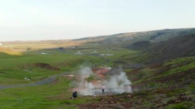 İzlanda 'da kraterleri buharlaştıran ve turist keşifleri yapan hava aracı manzaralı jeotermal alan. Fümerollerin kuşların gözü, doğadaki güzellik.