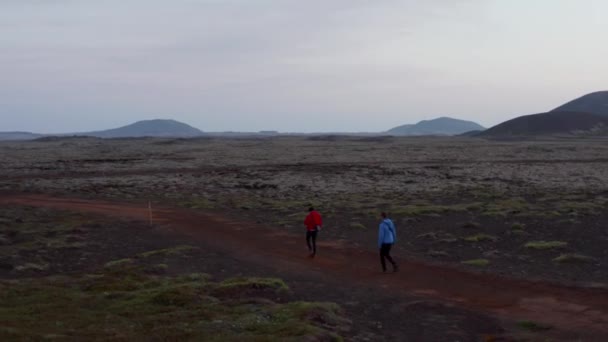 Fåglar ögon omloppsbana tre personer vandrare vandrar höglandet på Island utforska. Flygfoto tre upptäcktsresande gångväg utflykt utforska extrema islandskap — Stockvideo