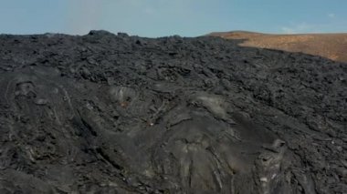 Önceki patlamanın engebeli yüzeyini geri çek. Manzarada büyük yeni lav alanı. Fagradalsfall volkanı. İzlanda, 2021