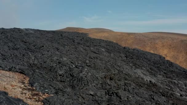 Leť přes tmavý pruh chladícího vulkanického materiálu. Pevný proud lávy po erupci. Sopka Fagradalsfjall. Island, 2021 — Stock video