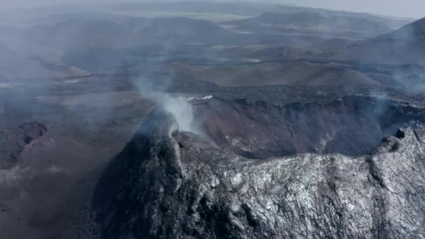 Images en gros plan du cratère volcanique. Surface métallique brillante de la couche de lave sur la pente de la colline. Fumée blanche sortant de l'évent. Volcan Fagradalsfjall. Islande, 2021 — Video