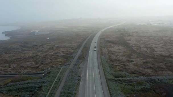 Vista aérea hacia adelante del vuelo sobre el paisaje icelandés impresionante y surrealista con la conducción de coches en Ring Road. Tranquila y tranquila carretera de un coche a través de la carretera más importante de Islandia — Vídeos de Stock