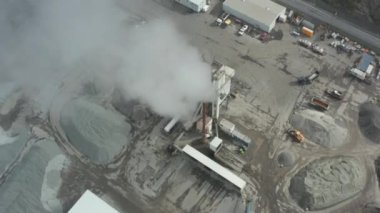Drone görüntüsü İzlanda 'daki merkezi Colas tesisinin yörüngesinde. Kurulum, makine ve malzeme yığınlarıyla asfalt endüstrisinin havadan görünüşü