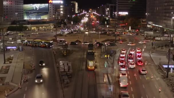 Forwards fly above tram tracks. Elevated footage of heavy traffic on road intersection in evening rush hour. Warsaw, Poland — Stock Video