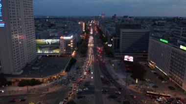 Şehir merkezindeki kalabalık çok şeritli yolun ve kavşağın görüntüleri. Geniş bulvarda akşam trafiği. Varşova, Polonya