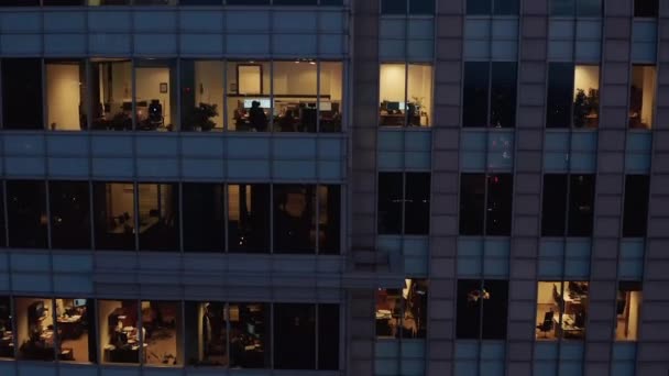 Wzrastające przechylone nagrania oświetlonych okien w budynku wysokiego biznesu w mieście. Wieczorny widok na biura. Warszawa, Polska — Wideo stockowe