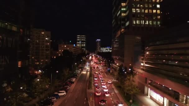 На вечерних улицах города прямо над проезжей частью пролетает пробка. Длинная очередь машин, ожидающих перед перекрестком дорог. Уорсоу, Польша — стоковое видео