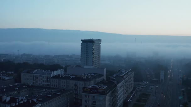 Der Orbit schoss um ein hohes altes Wohnhaus, das sich über die umgebende Stadtentwicklung erhebt. Blaugetönter nebliger Morgen in einem Wohnviertel. Warschau, Polen — Stockvideo