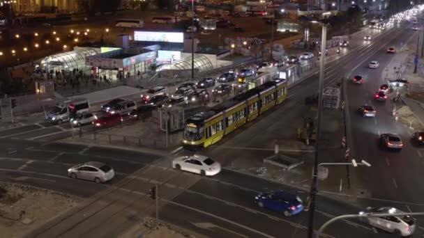 Wzrastające ujęcie tramwaju czekającego przed skrzyżowaniem. Wieczór duży ruch w centrum miasta. Warszawa, Polska — Wideo stockowe