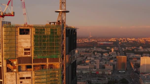 Voe em torno do topo do canteiro de obras de construção de arranha-céus. revelando vista panorâmica aérea do bairro urbano. Varsóvia, Polónia — Vídeo de Stock