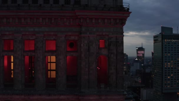 Control deslizante apretado del edificio histórico iluminado rojo. Rascacielos del centro al atardecer. Varsovia, Polonia — Vídeos de Stock