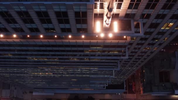 Zejście pod wysokim kątem z wysokim budynkiem biurowym. Nachylić się widok przez okno na ludzi pracujących w godzinach wieczornych. Warszawa, Polska — Wideo stockowe