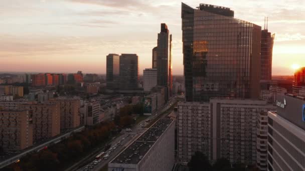 Slide και pan πλάνα από σύγχρονα κτίρια υψηλής ανόδου με γυαλιστερές προσόψεις που αντανακλούν τη δύση του ήλιου. Βαρσοβία, Πολωνία — Αρχείο Βίντεο