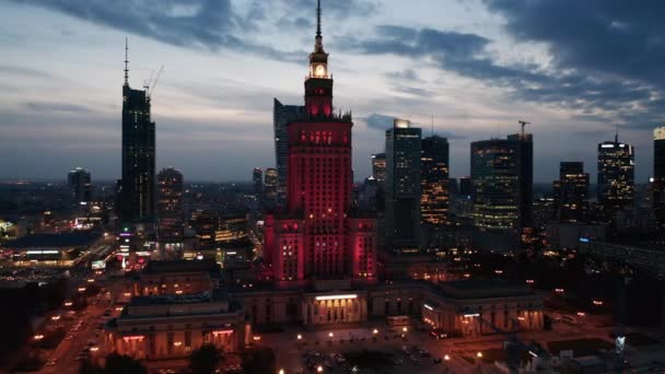 Rojo iluminado monumental gran altura Palacio de Cultura y Ciencia y rascacielos del centro en la hora del crepúsculo. Varsovia, Polonia — Vídeos de Stock