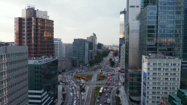 Vycházející záběry rušné široké ulice a křižovatky okruhů s tramvajovými tratěmi. Vysoké kancelářské a bytové budovy. Varšava, Polsko — Stock video